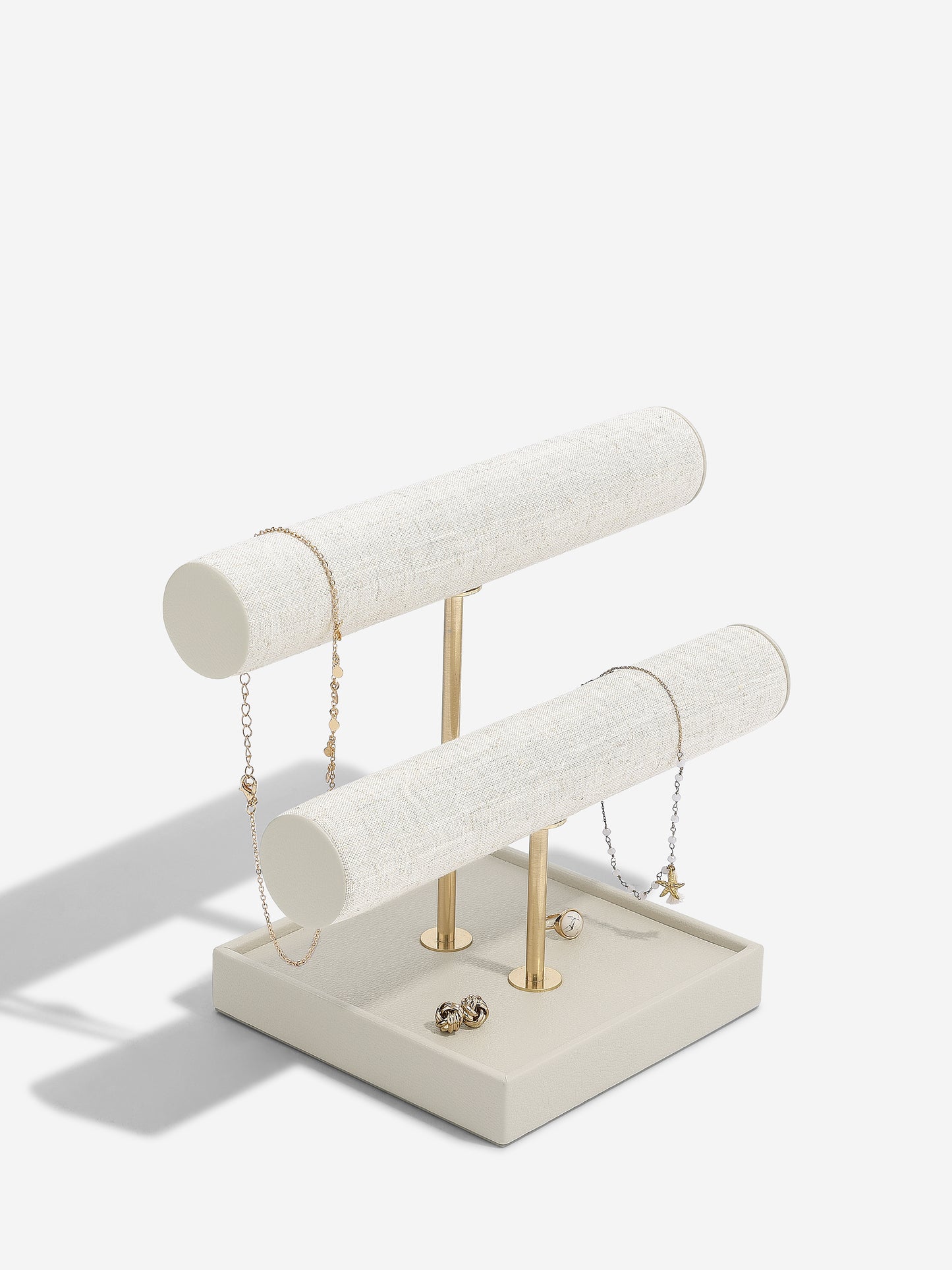 Oatmeal and linen jewelry stand with necklaces on a white background