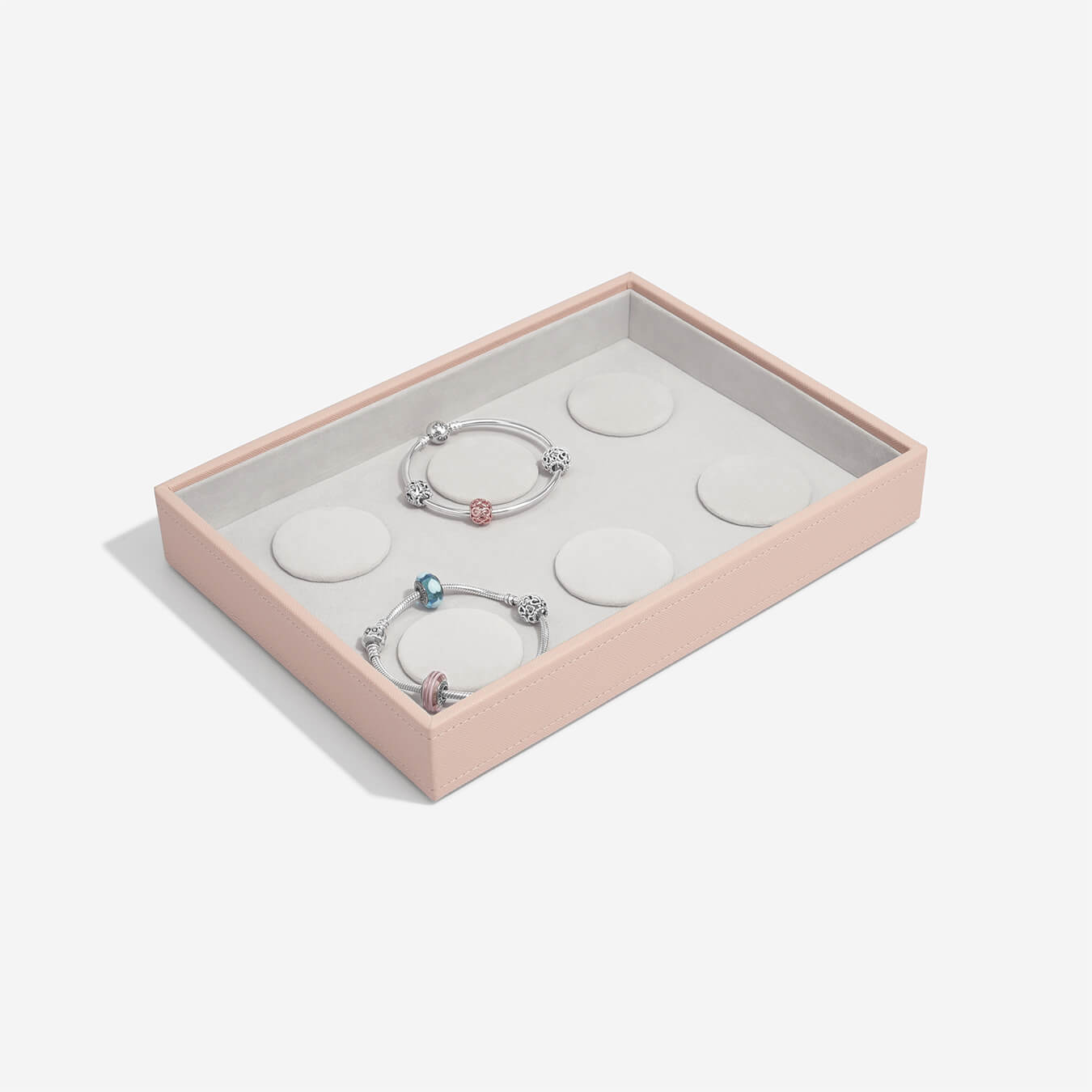 Set of three bracelets in a pink jewelry box on a white background