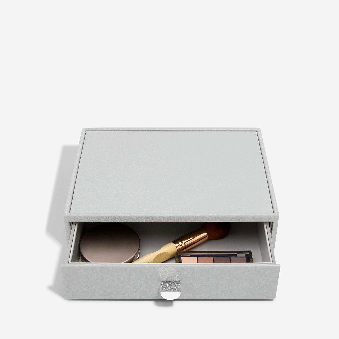 Pebble grey makeup storage drawer with open drawer showing cosmetic items on a white background