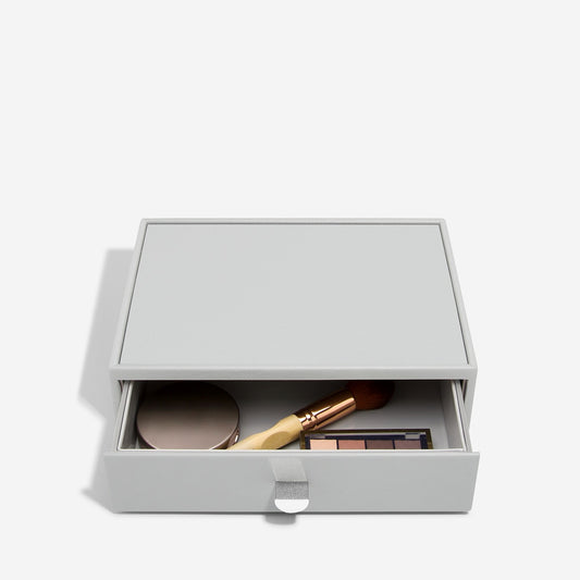 Pebble grey makeup storage drawer with open drawer showing cosmetic items on a white background