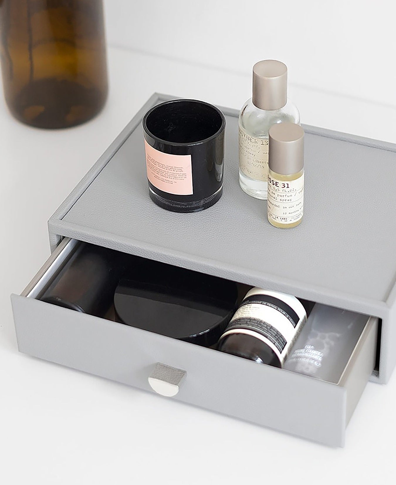 pebble grey drawer with skincare products on a white surface