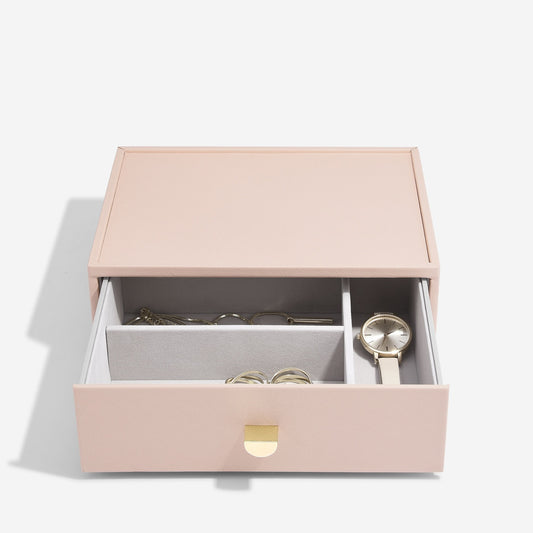 Pink jewelry box with jewelry items on a white background