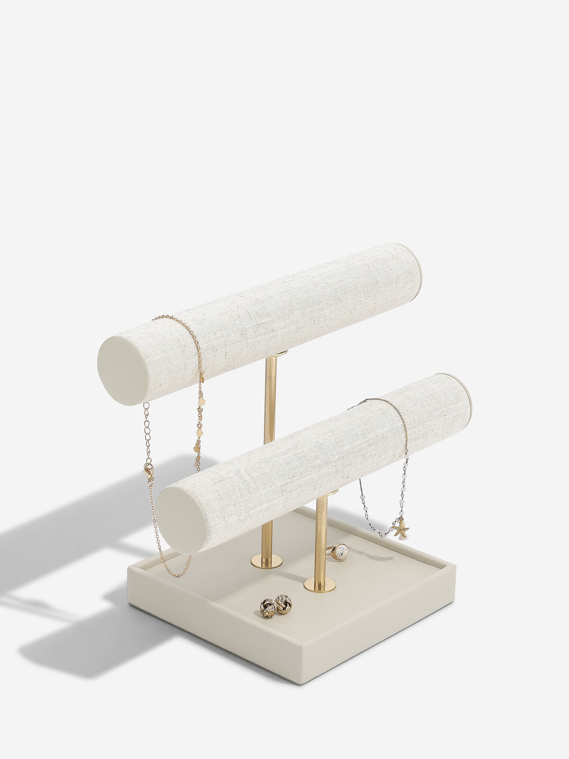 Oatmeal and linen jewelry stand with necklaces on a white background