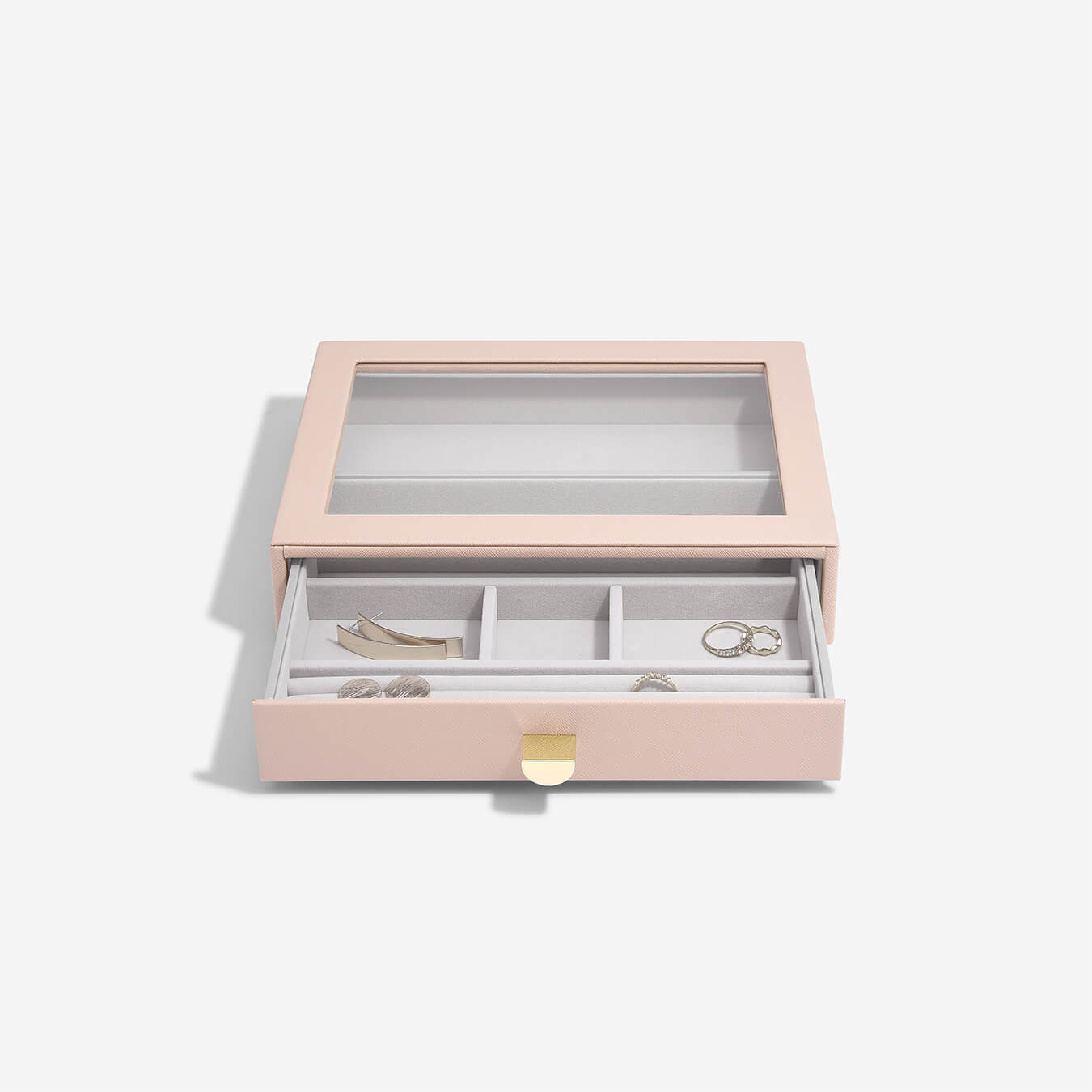 Pink jewelry box with jewelry items on a light gray background