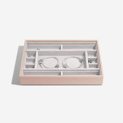 Pink jewelry box with silver bracelets on a white background