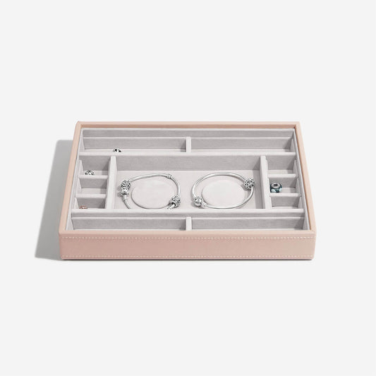 Pink jewelry box with silver bracelets on a white background