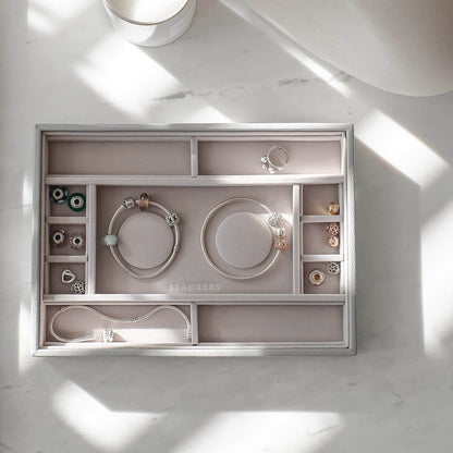 Jewelry organizer with various items on a light gray surface