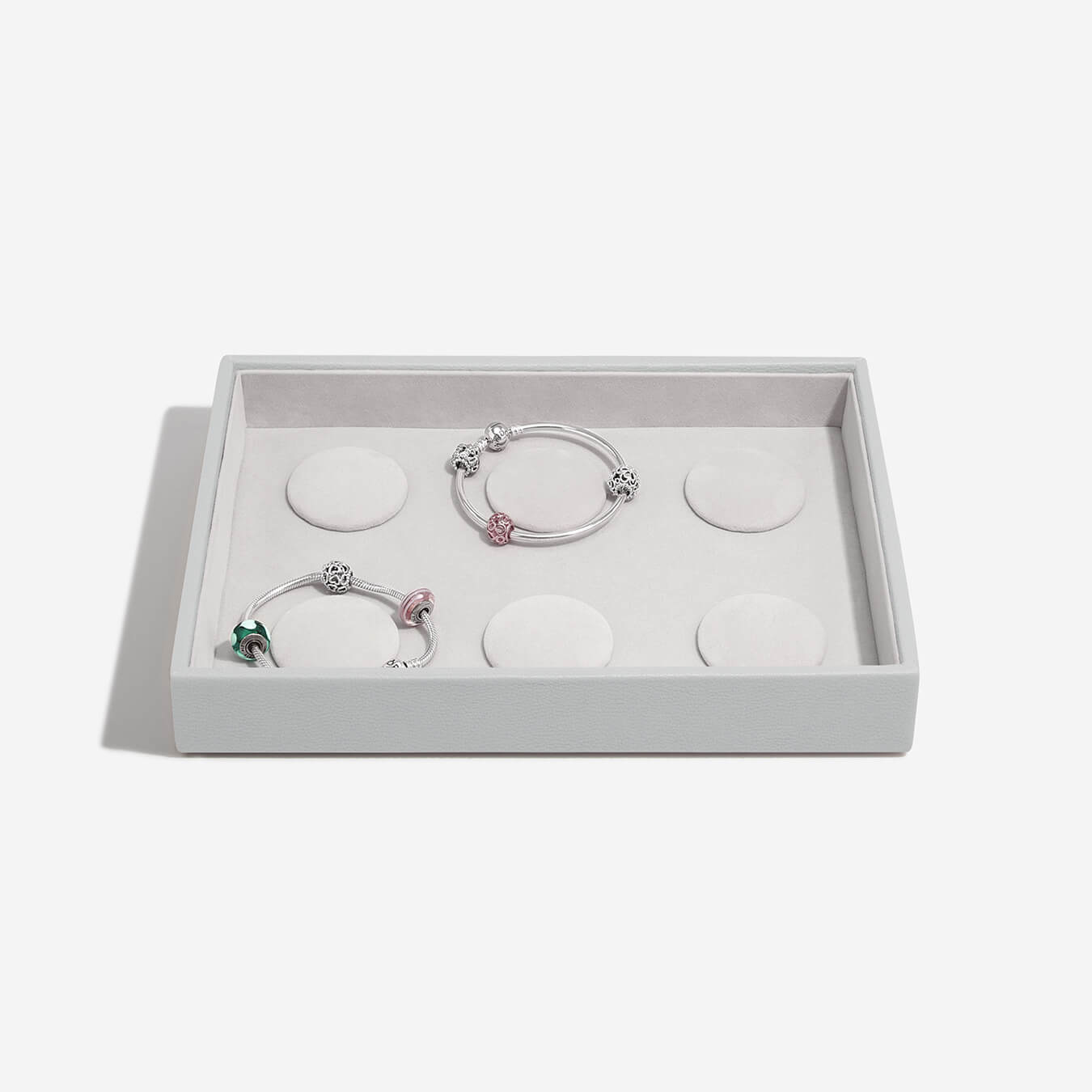 Set of three bracelets in a grey box on a light gray background