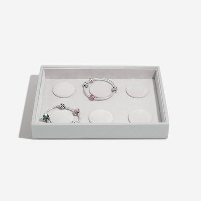 Set of three bracelets in a grey box on a light gray background