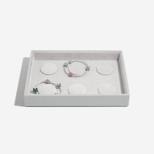 Set of three bracelets in a grey box on a light gray background