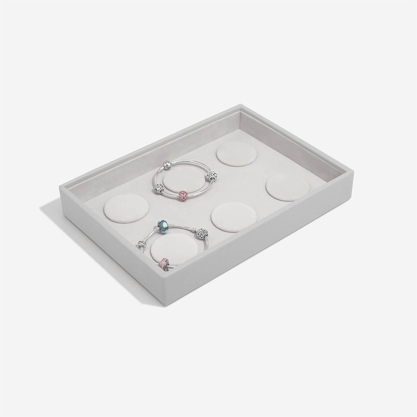 Set of bracelets in a grey jewelry box on a light gray background
