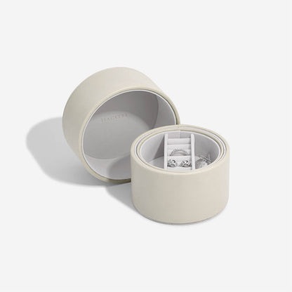 Open oatmeal colour jewelry box with jewelry inside on a white background
