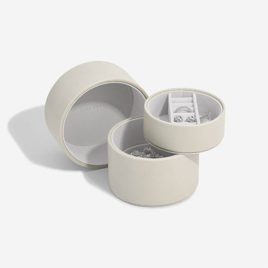 Open oatmeal colour jewelry box with jewelry inside on a white background