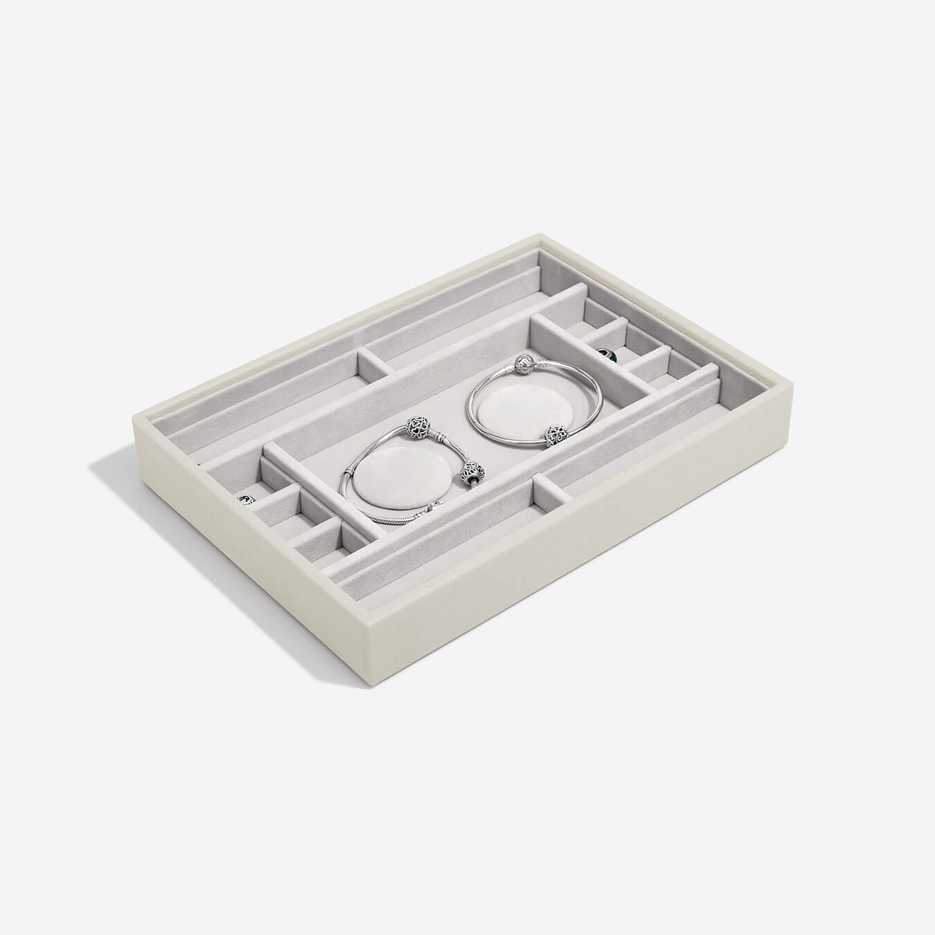 Jewelry organizer with compartments holding charm bracelets on a white background