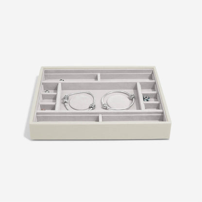 Jewelry organizer with compartments holding bracelets on a white background