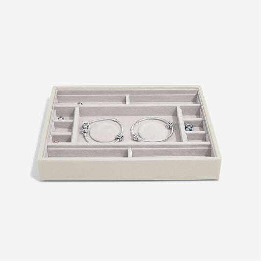 Jewelry organizer with compartments holding bracelets on a white background