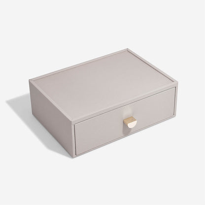 Taupe storage box with a gold handle on a white background